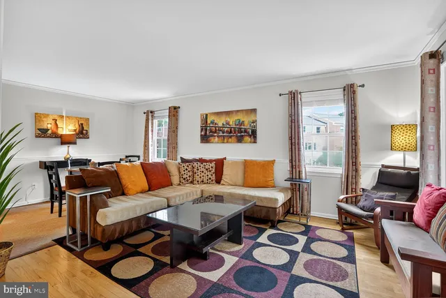a living room with furniture and a flat screen tv with wooden floor