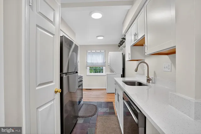 a kitchen with white cabinets and stainless steel appliances