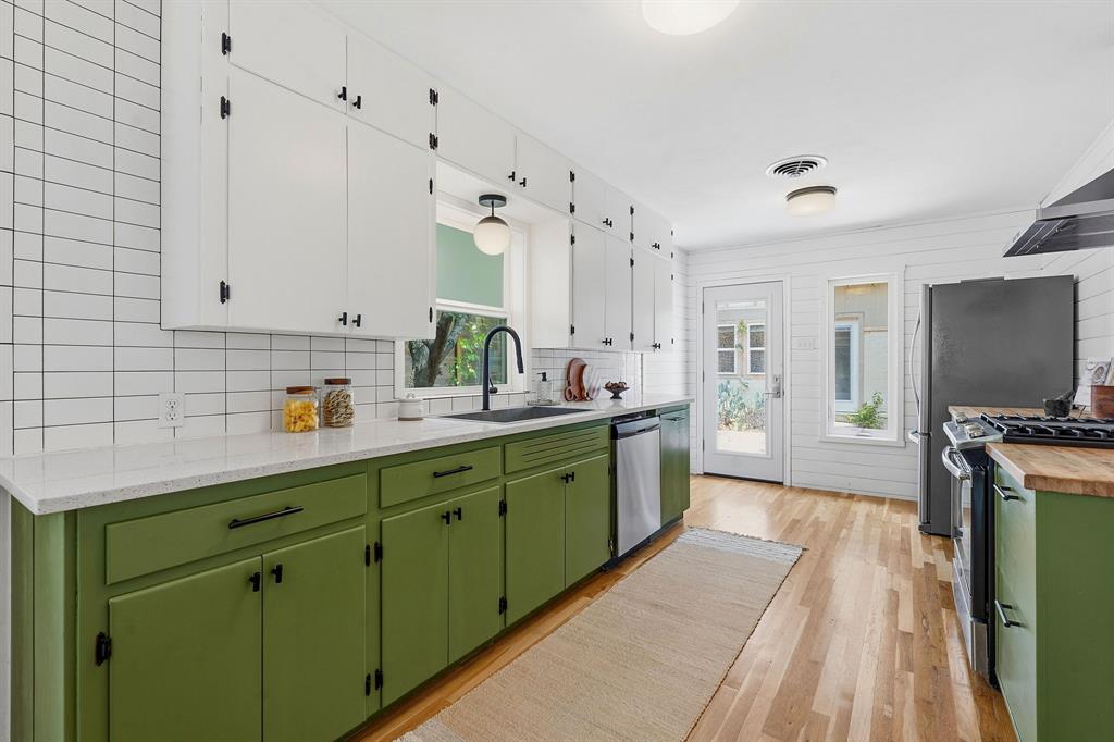 900 Stark Street Austin, TX 78756 - Photo 8 of 25 A vibrant kitchen boasts ample counter space, a modern sink, and durable wood flooring.