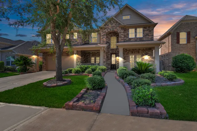 a front view of a house with a yard and potted plants