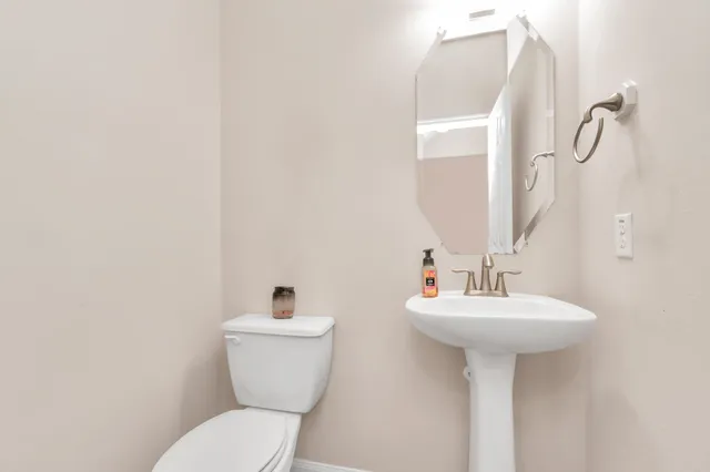 a bathroom with a sink mirror and toilet