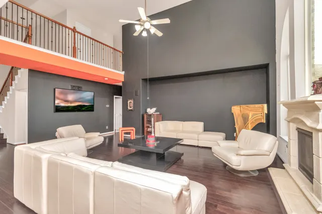 a living room with furniture a flat screen tv and a window