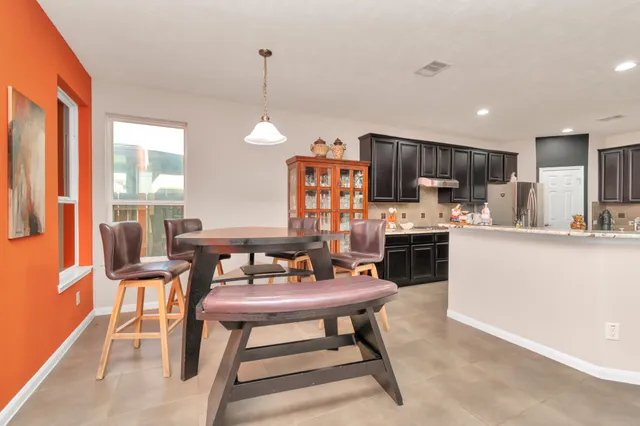 a kitchen with a table chairs refrigerator and chairs