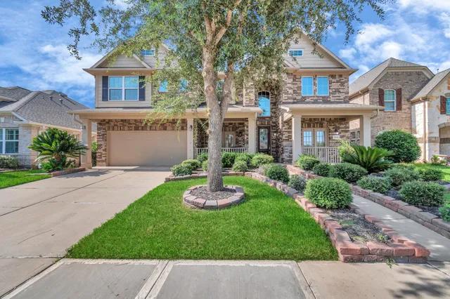 a front view of a house with a garden and plants