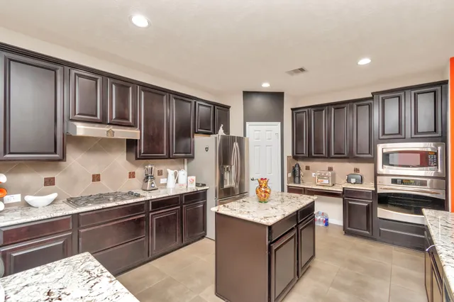a kitchen with a sink stove top oven and refrigerator