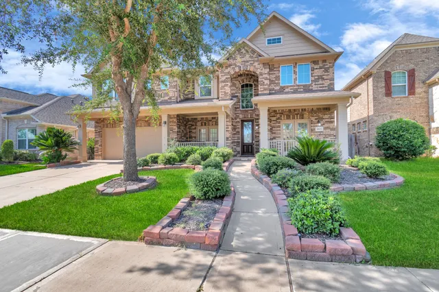 a front view of a house with a yard and potted plants