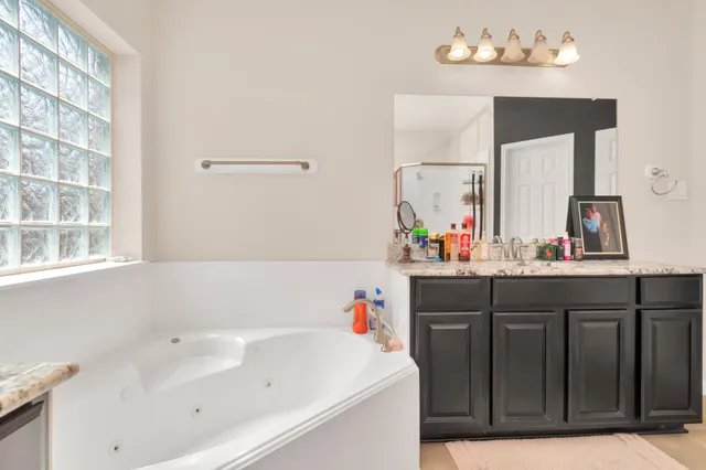 a bathroom with a bathtub sink and mirror