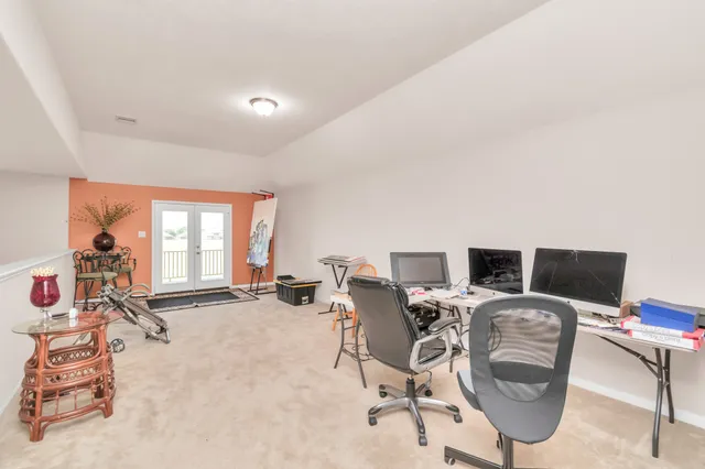 a view of a workspace with furniture and a window