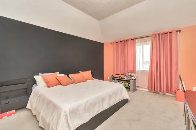 a bedroom with a bed and large windows