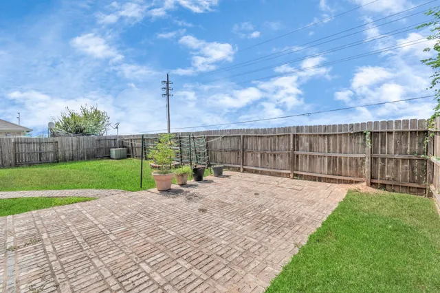 a view of a backyard with wooden fence