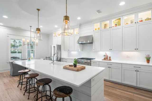 a kitchen with a sink a center island stainless steel appliances and cabinets