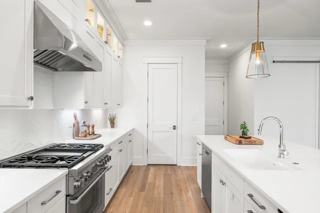 a kitchen with stainless steel appliances a sink a stove a refrigerator and cabinets