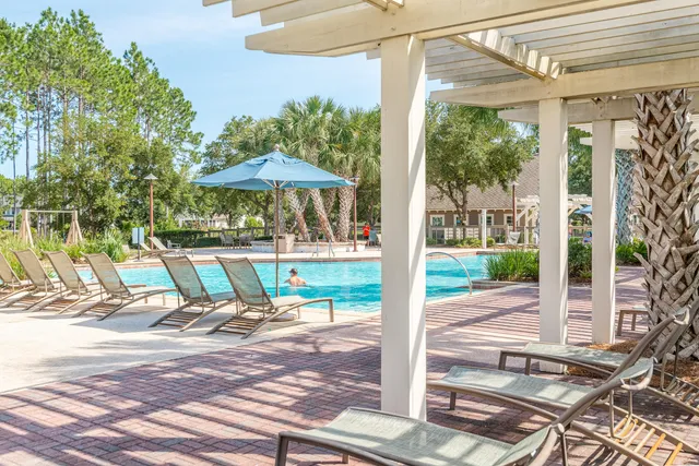 a view of a patio with table and chairs potted plants and palm trees