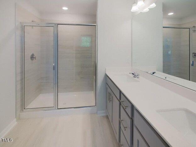 113 Vanilla Orchid Lane Garner, NC 27529 - Photo 11 of 32 a bathroom with a double vanity sink a mirror and a shower