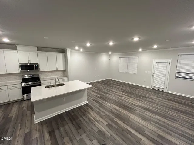 a kitchen with a sink a refrigerator and cabinets