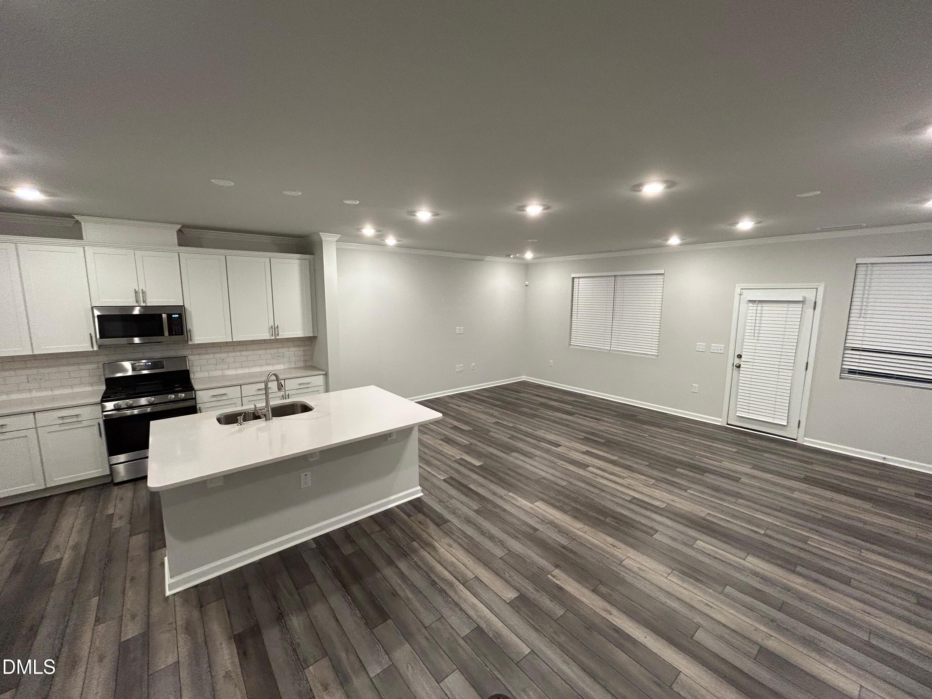 113 Vanilla Orchid Lane Garner, NC 27529 - Photo 16 of 32 a view of kitchen with wooden floor and electronic appliances