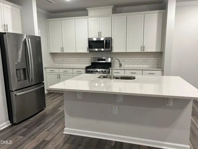 a kitchen with a refrigerator a stove a microwave and cabinets