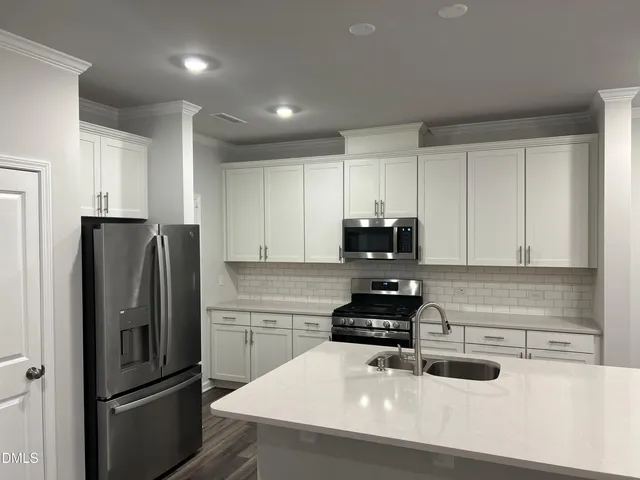 a kitchen with stainless steel appliances a refrigerator sink and stove