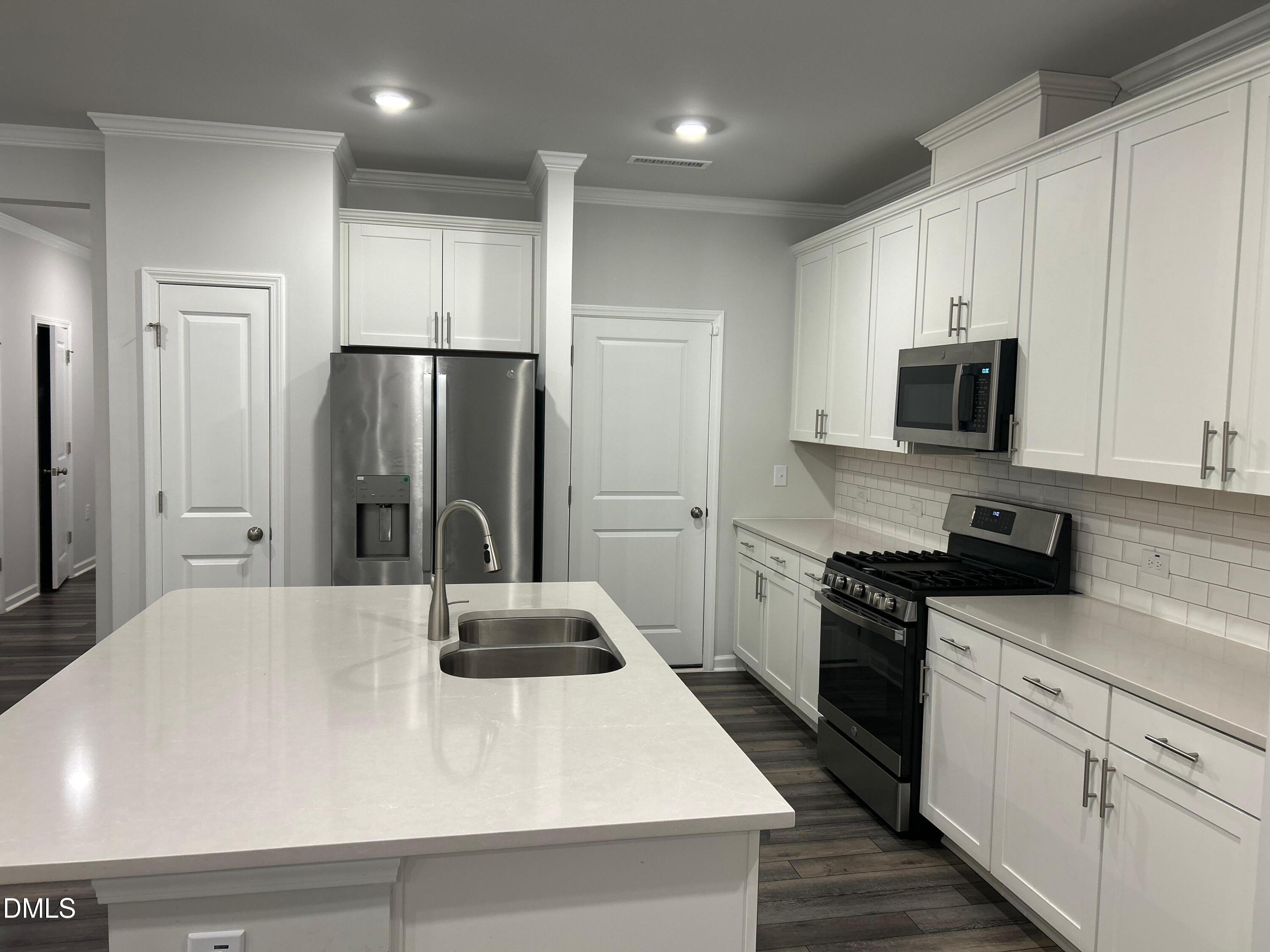 113 Vanilla Orchid Lane Garner, NC 27529 - Photo 19 of 32 a kitchen with stainless steel appliances a refrigerator sink and stove