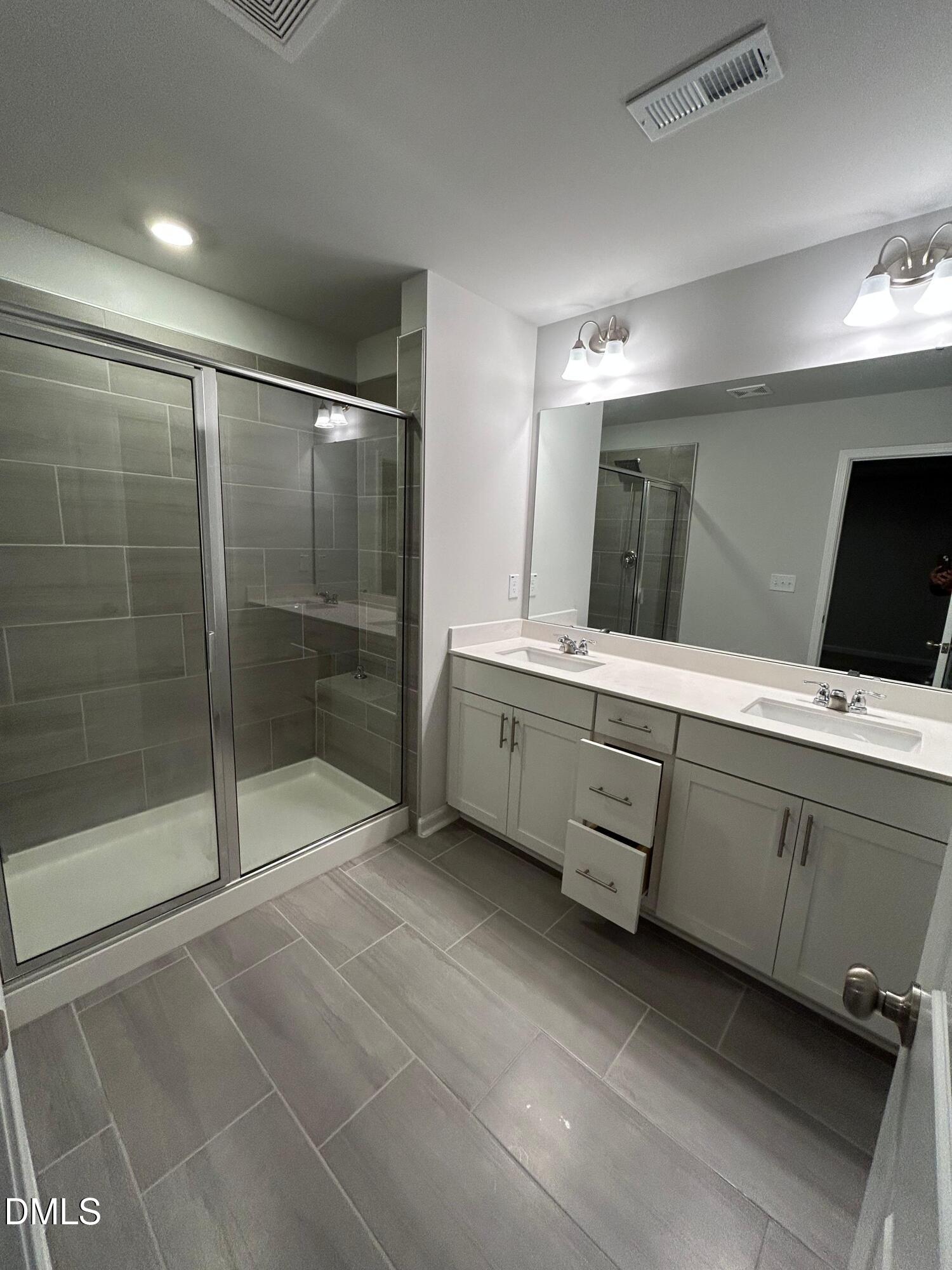 113 Vanilla Orchid Lane Garner, NC 27529 - Photo 23 of 32 a bathroom with a double vanity sink mirror and shower