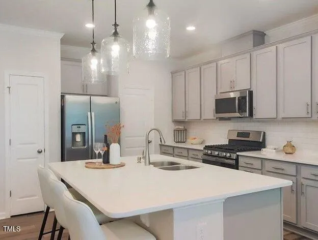 a kitchen with stainless steel appliances a dining table chairs refrigerator and microwave