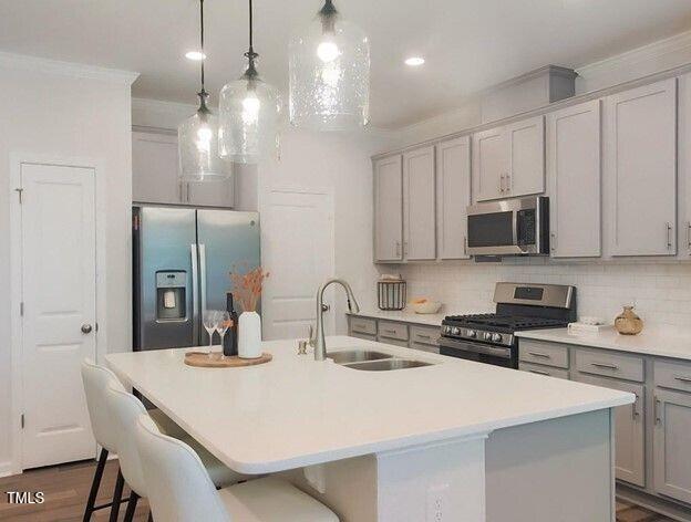 113 Vanilla Orchid Lane Garner, NC 27529 - Photo 4 of 32 a kitchen with stainless steel appliances a sink a stove a refrigerator and cabinets