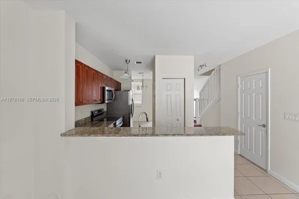 a living room with kitchen island granite countertop furniture and a large window