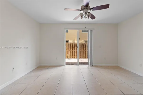 a view of an empty room and chandelier fan