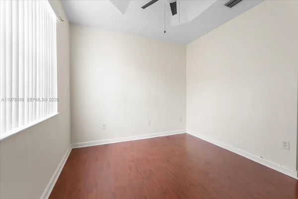 an empty room with a window and a ceiling fan