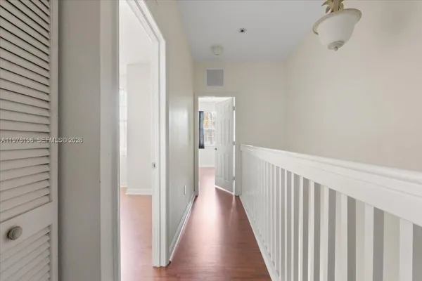 a view of a hallway with wooden floor