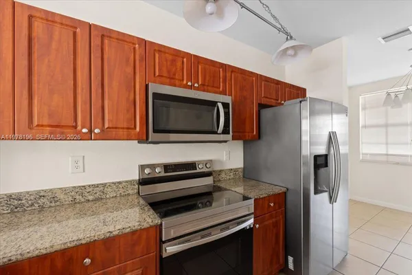 a kitchen with stainless steel appliances granite countertop a refrigerator microwave and stove top oven