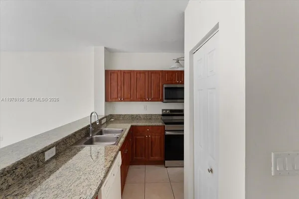 a kitchen with granite countertop a sink and wooden cabinets