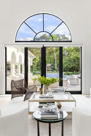 a living room with large windows and a table