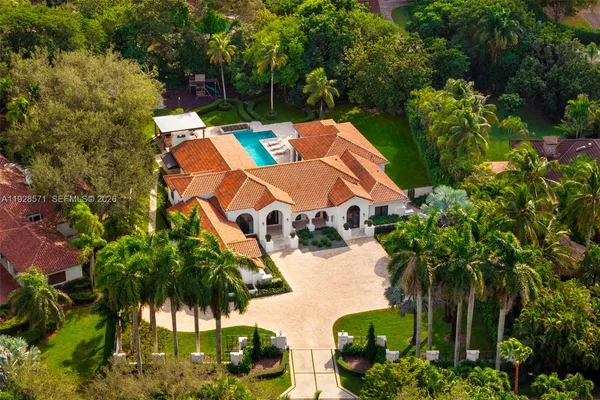 an aerial view of a house with yard and patio