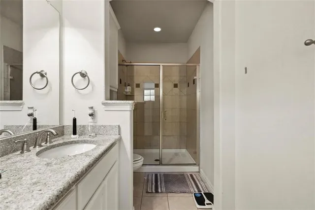a bathroom with a granite countertop sink a toilet and a shower