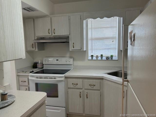 1903 Southwest Palm City Road, Unit H Stuart, FL 34994 - Photo 4 of 31 a kitchen with cabinets appliances and a sink