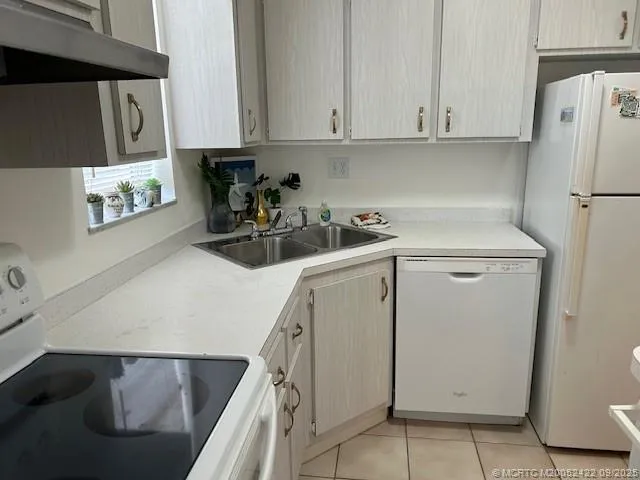 a kitchen with a refrigerator sink and cabinets