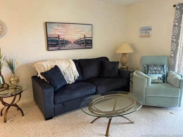 a living room with furniture a lamp and a rug