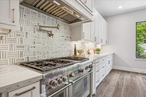 a kitchen with sink stove and cabinets