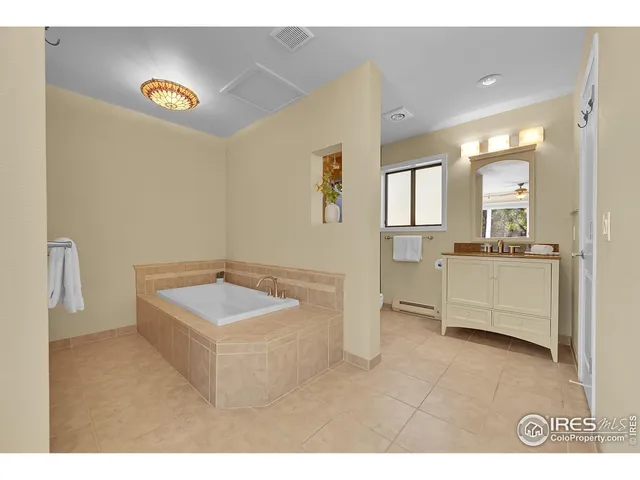 a bathroom with a sink a tub and a window