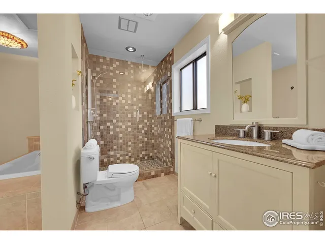 a bathroom with a sink a toilet a mirror and shower