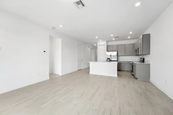 a view of kitchen with kitchen island a sink wooden floor and white stainless steel appliances