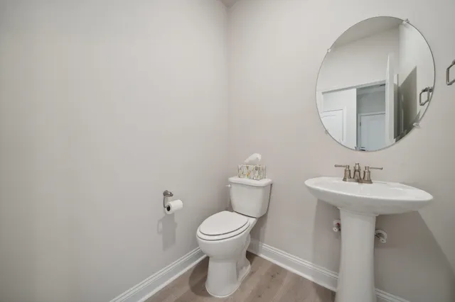 a bathroom with a toilet a sink and mirror