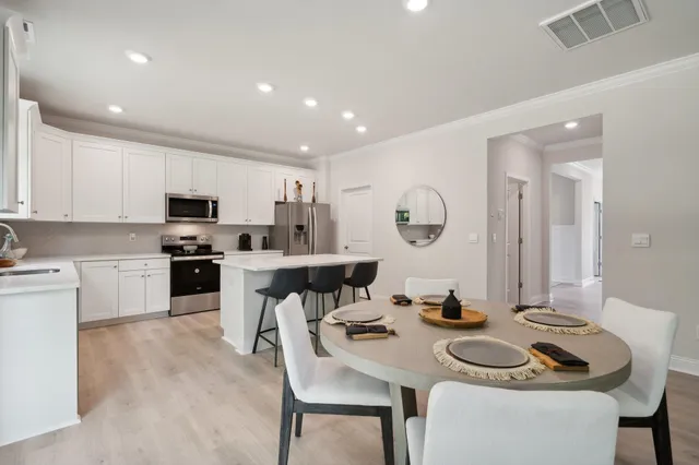 a kitchen with a dining table chairs stove microwave and cabinets
