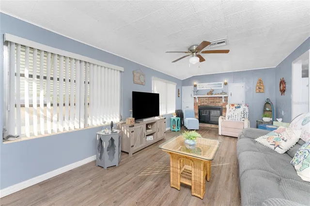 a living room with furniture a flat screen tv and a large window