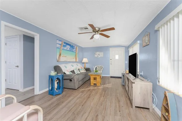 a living room with furniture wooden floor and a flat screen tv