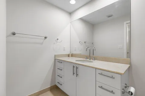 a bathroom with a granite countertop sink and a mirror