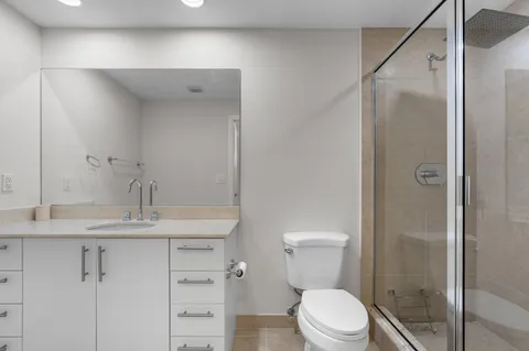a bathroom with a sink a toilet and shower