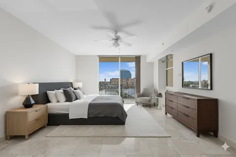 a spacious bedroom with a large bed and a chandelier