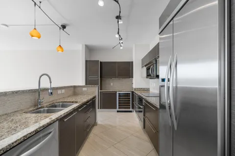 a kitchen with stainless steel appliances granite countertop a sink and refrigerator